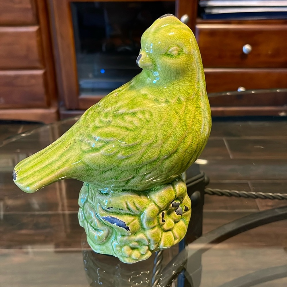 Ceramic lime green bird atop flowers design